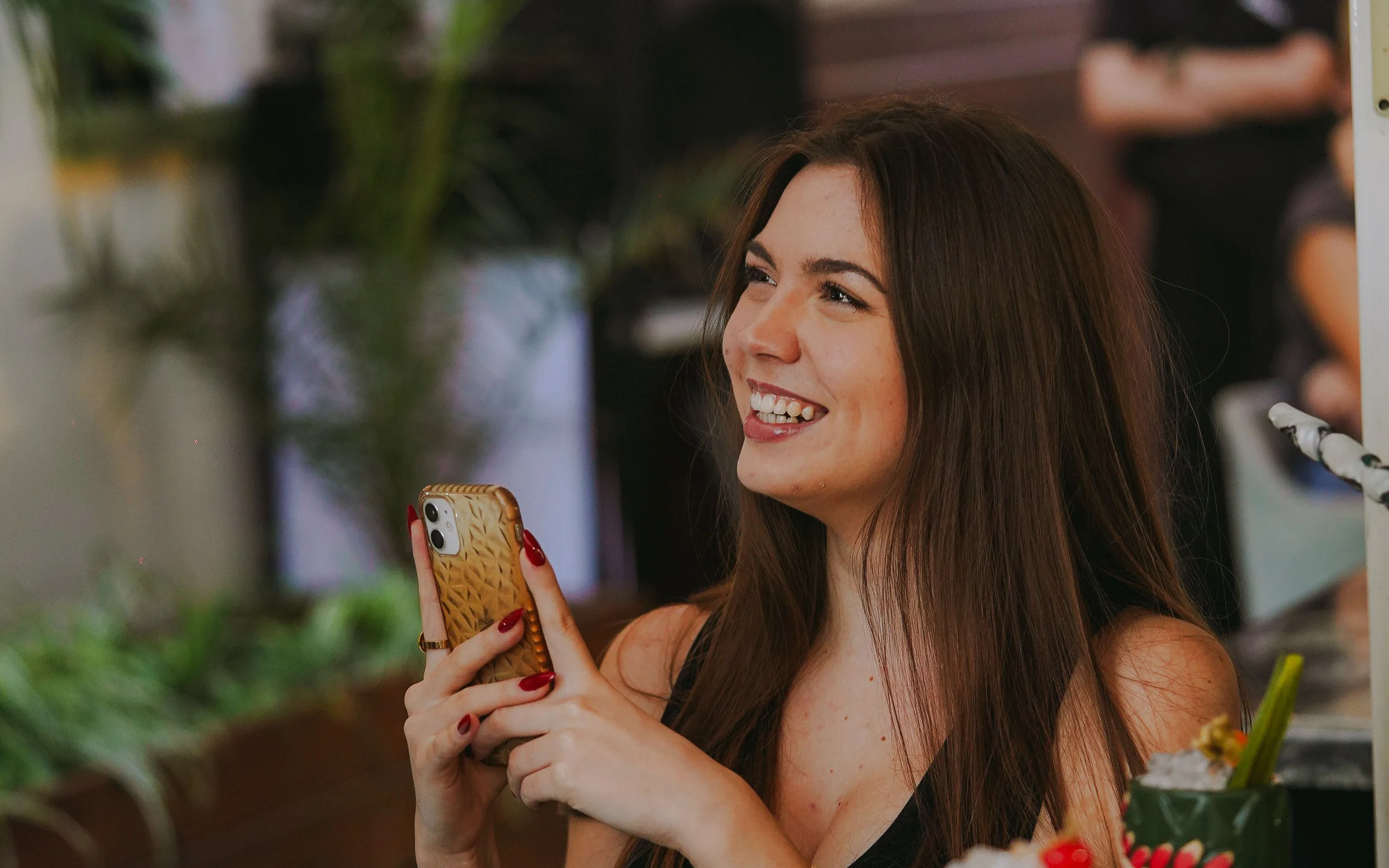 Una clienta consulta su teléfono en un restaurante luminoso